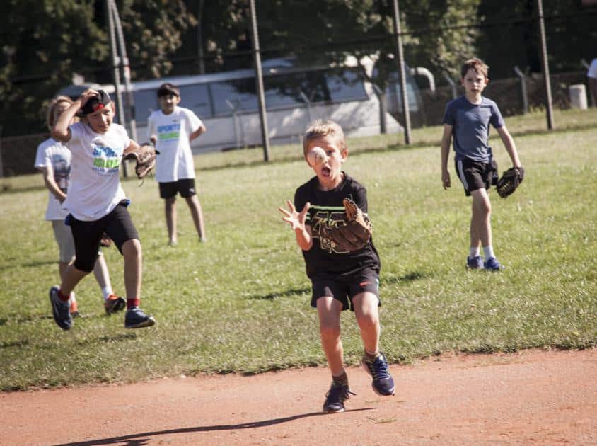 Coole Sportarten im Ballsport: Baseball Kinder spielen Baseball und der Fänger fängt
