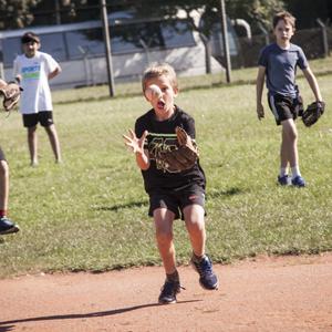 Kind spielt Baseball in den Feriencamps Berlin auf dem Tempelhofer Feld