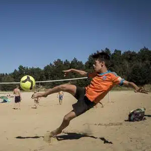 Kind spielt am Strand Fußball in den Feriencamps Wolfsburg im Allerpark