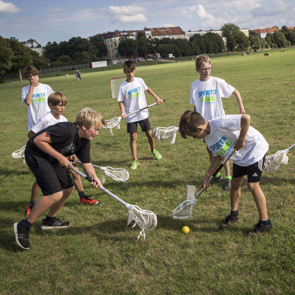 Eine Gruppe von Kindern spielen Lacross im Sommercamp München #1