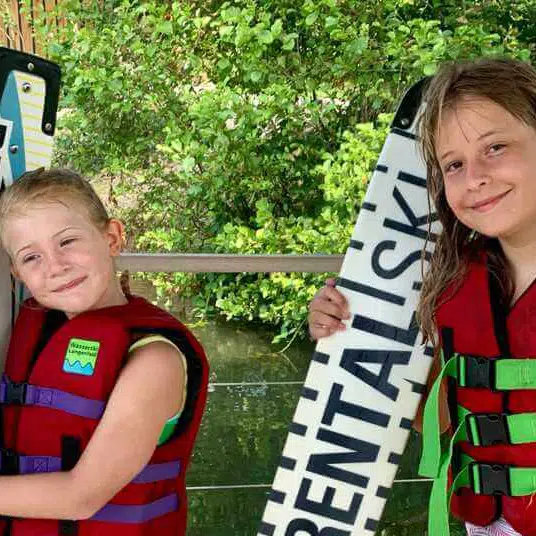 Sommercamp Köln #3 Blackfoot Beach: Zwei Mädchen mit Wasserskiern und Wakeboards haben Spaß
