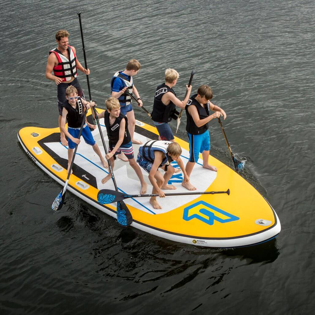 Coach mit Kindern auf einem Stand-up-Paddle Board auf dem Fühlinger See in den Feriencamps Köln