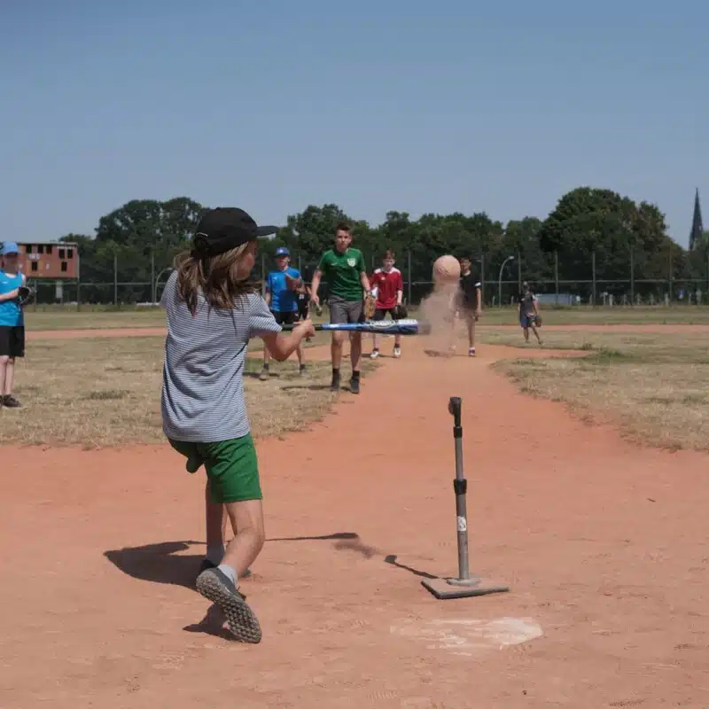 Kind beim Team Sports schlägt den Baseball ab in den Feriencamps für Kinder
