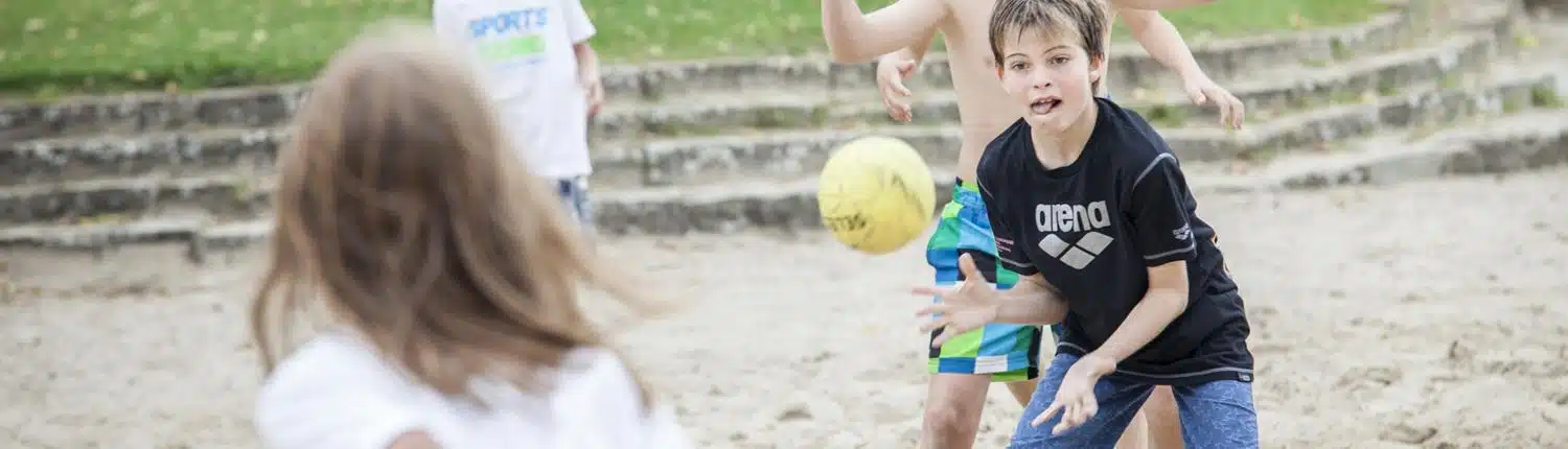 Kinder machen Team Sports und spielen Beach Volleyball in den Feriencamps Potsdam Waldbad Templin
